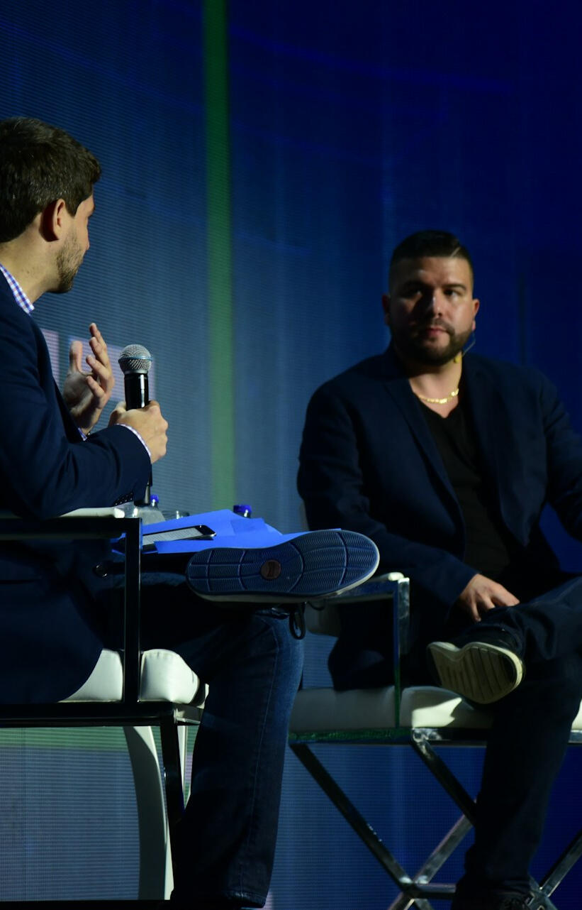 Leadership Dialogue in Public Forum Executive leadership interview discussing complex organisational issues on stage